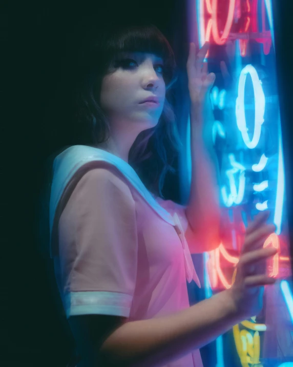 a woman is standing next to a neon sign
