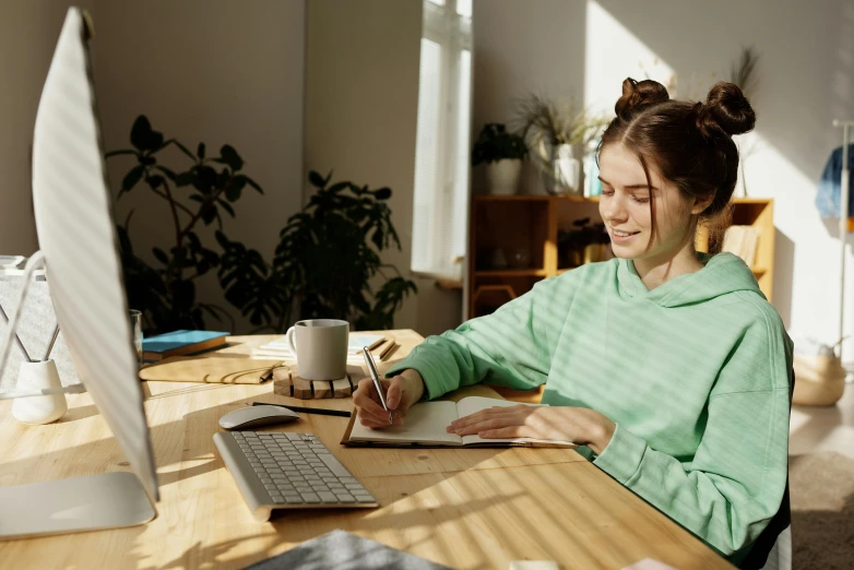 a young woman smiles while she uses her computer