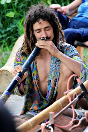 a man with long hair smoking a pipe