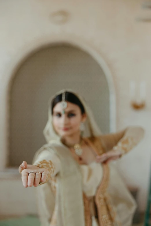 an indian woman wearing traditional dress is making the hand sign