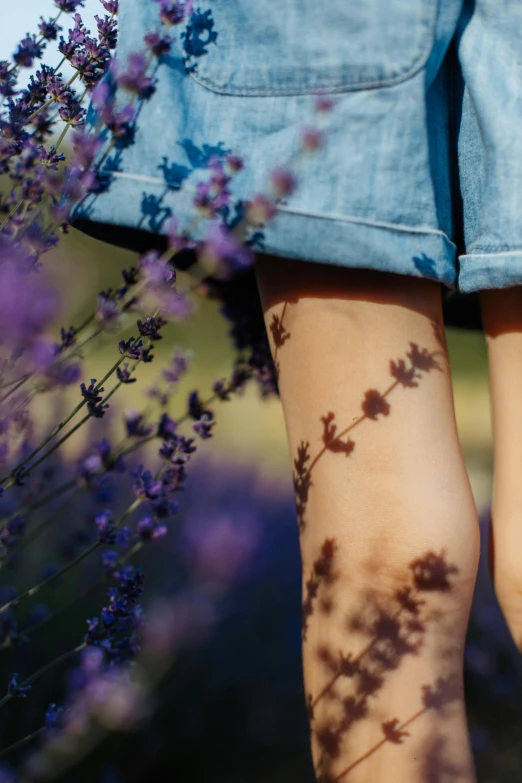 a woman's legs and flower are visible as she walks