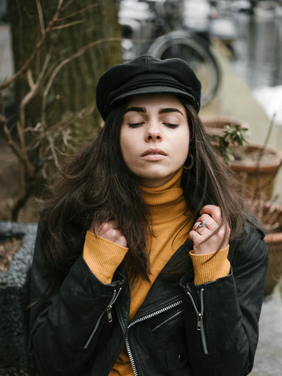 young woman standing in winter area with her hands on her neck