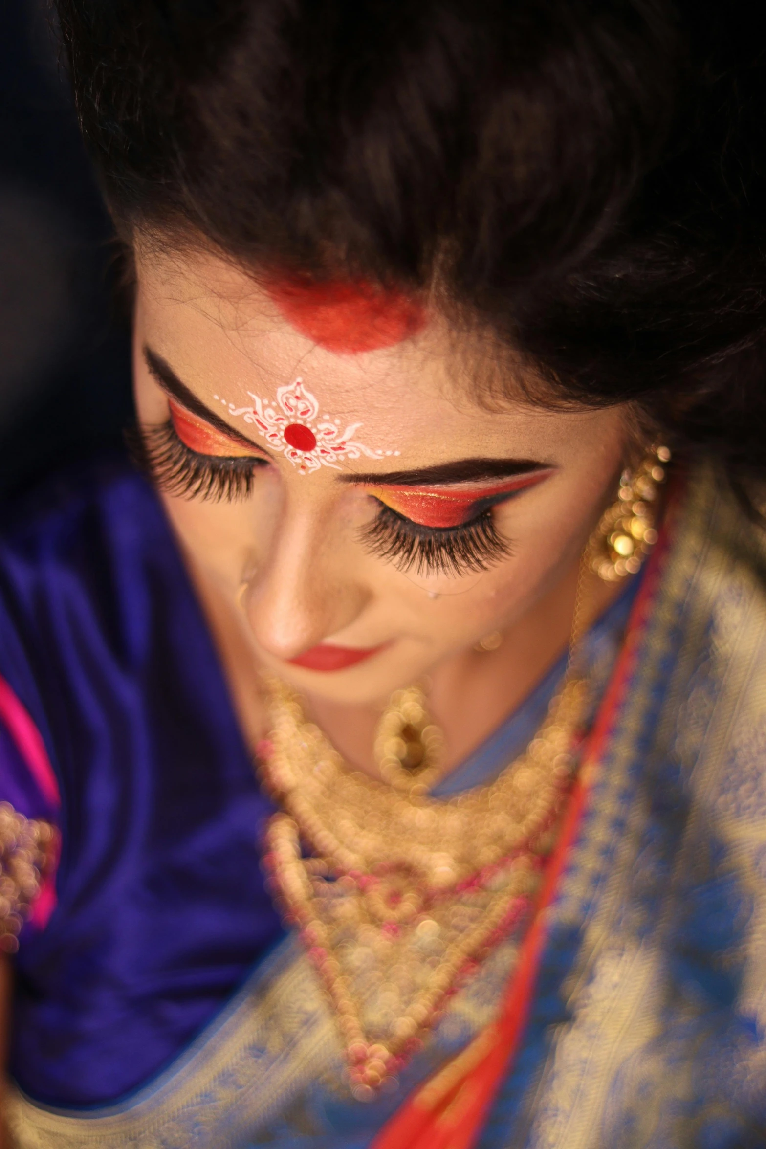 a woman with red makeup is looking down