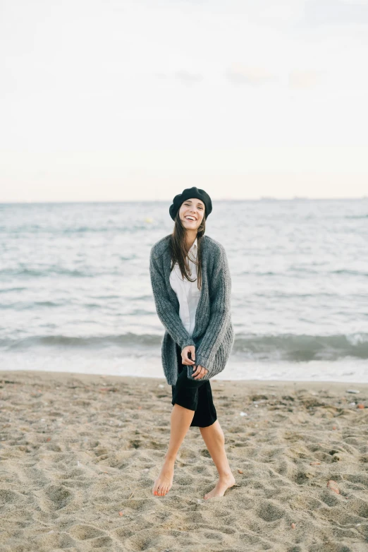 the woman in black shorts is smiling at the beach