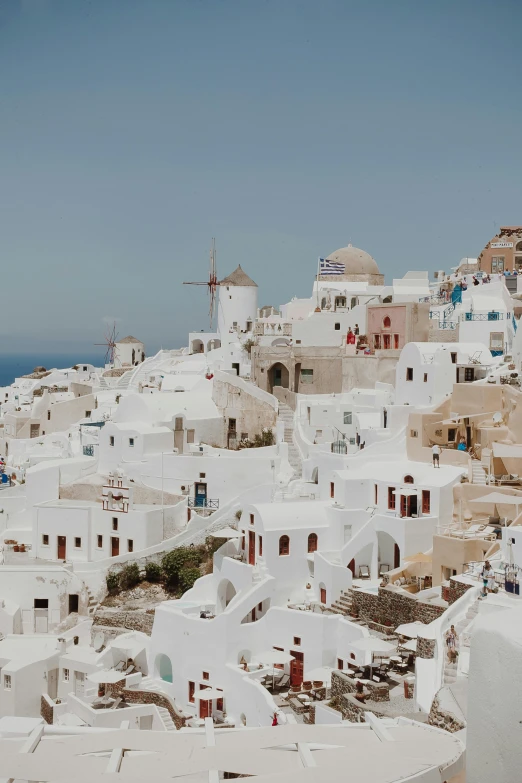 many white village buildings along a cliff face