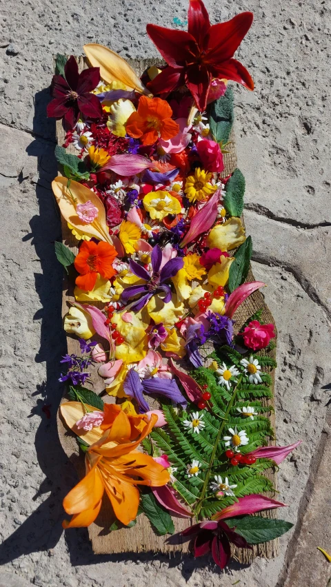 many flowers sitting on the cement on top of cement