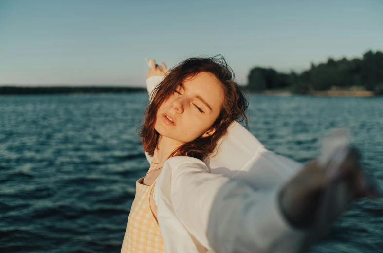 a woman is posing on the pier at the water's edge