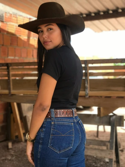 the woman wears a cowboy hat and jeans