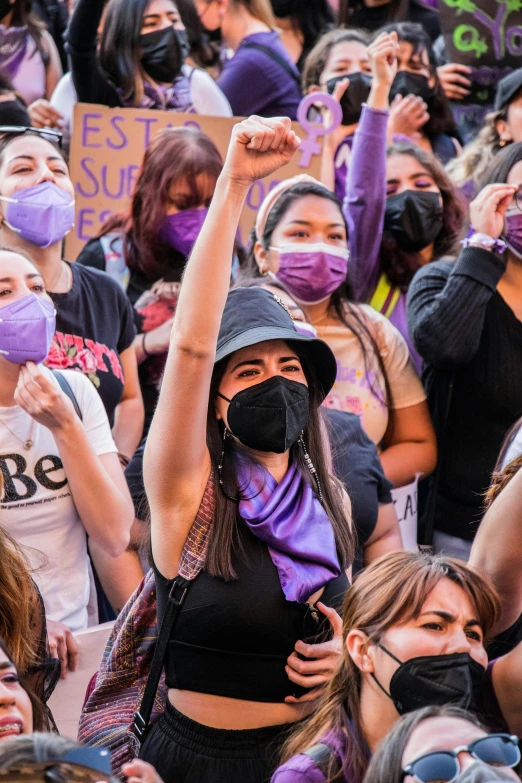 a crowd of people in the street with face masks