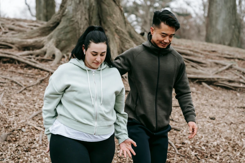 the man and woman are jogging in the woods