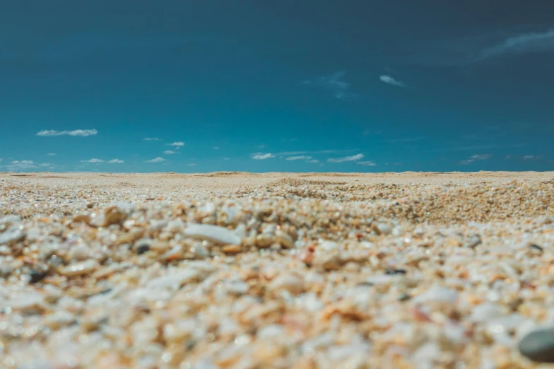 beach sand with small pieces of glass on top