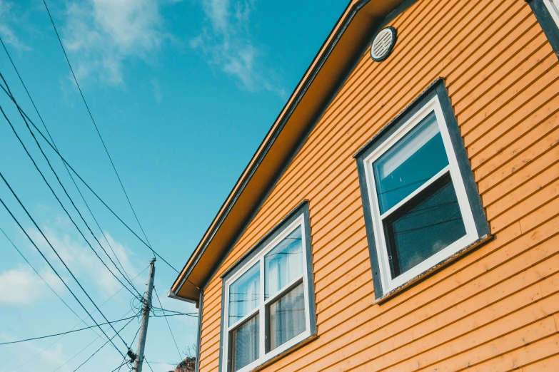 a red brick house has blue sky above it