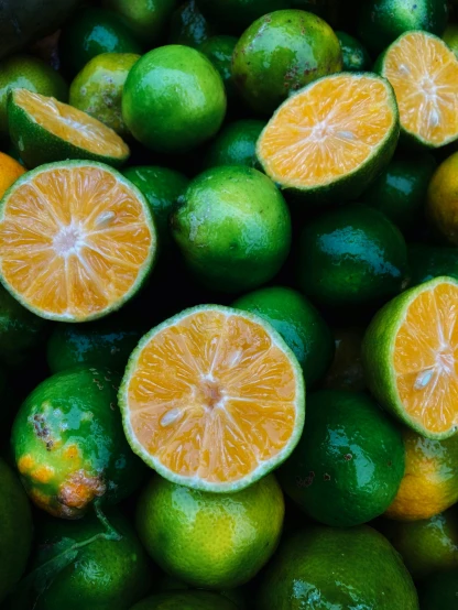 oranges, limes, and limes sit together on the table