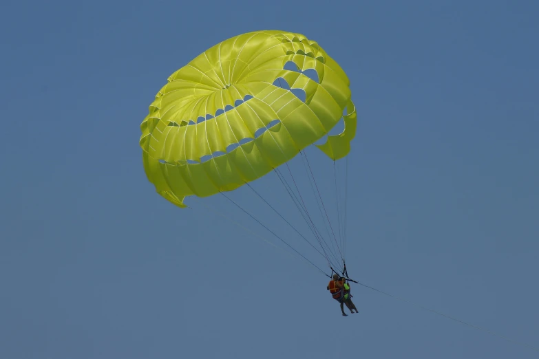 two people are parachute surfing in the air