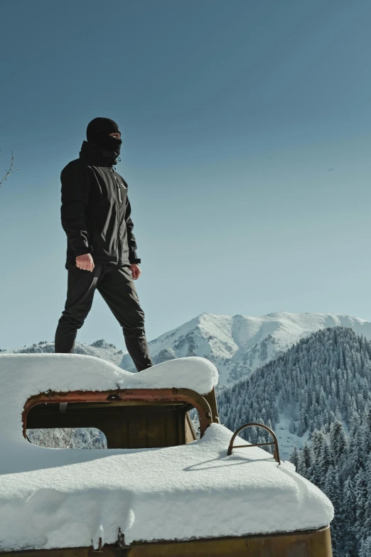 a man is standing atop of a truck and standing on it with his back turned against the roof