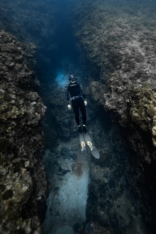 a scuba diver is submerged in an underwater cave