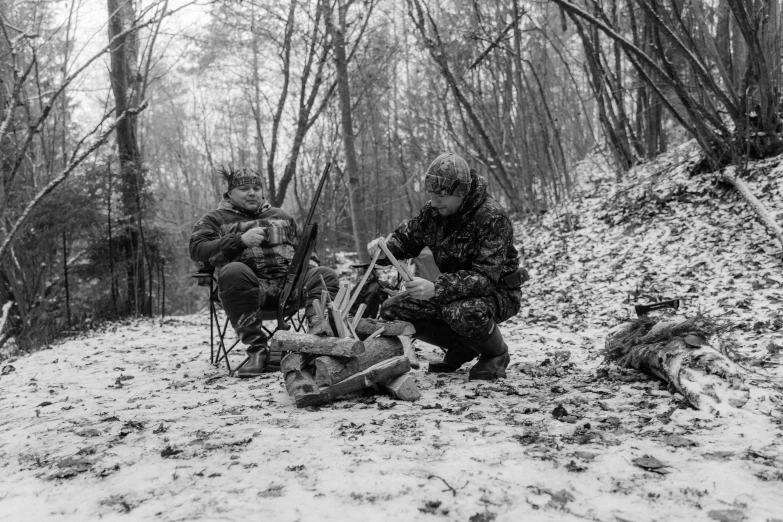 two people are sitting on the ground in the woods