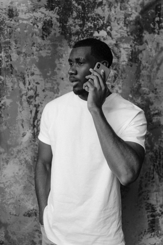 a man holding a phone to his ear and wearing a white shirt