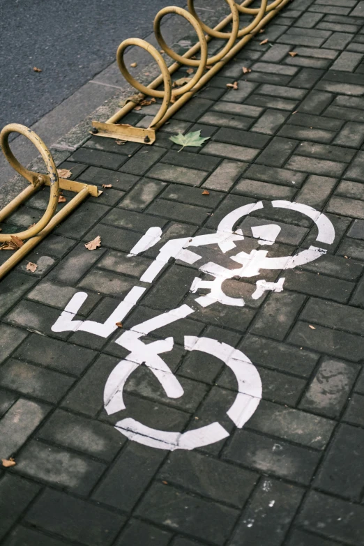 a bicycle lane is on the road near a bike rack