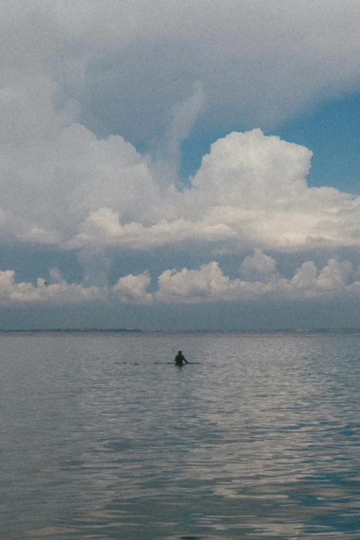 a lone boat is on the water under an overcast sky