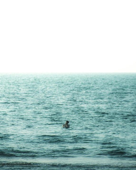 a person swimming in the ocean on a surfboard