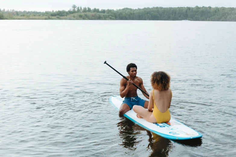 two people on paddles in the water with a boat