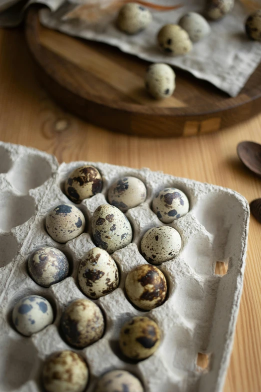 several brown eggs in an egg tray on a table