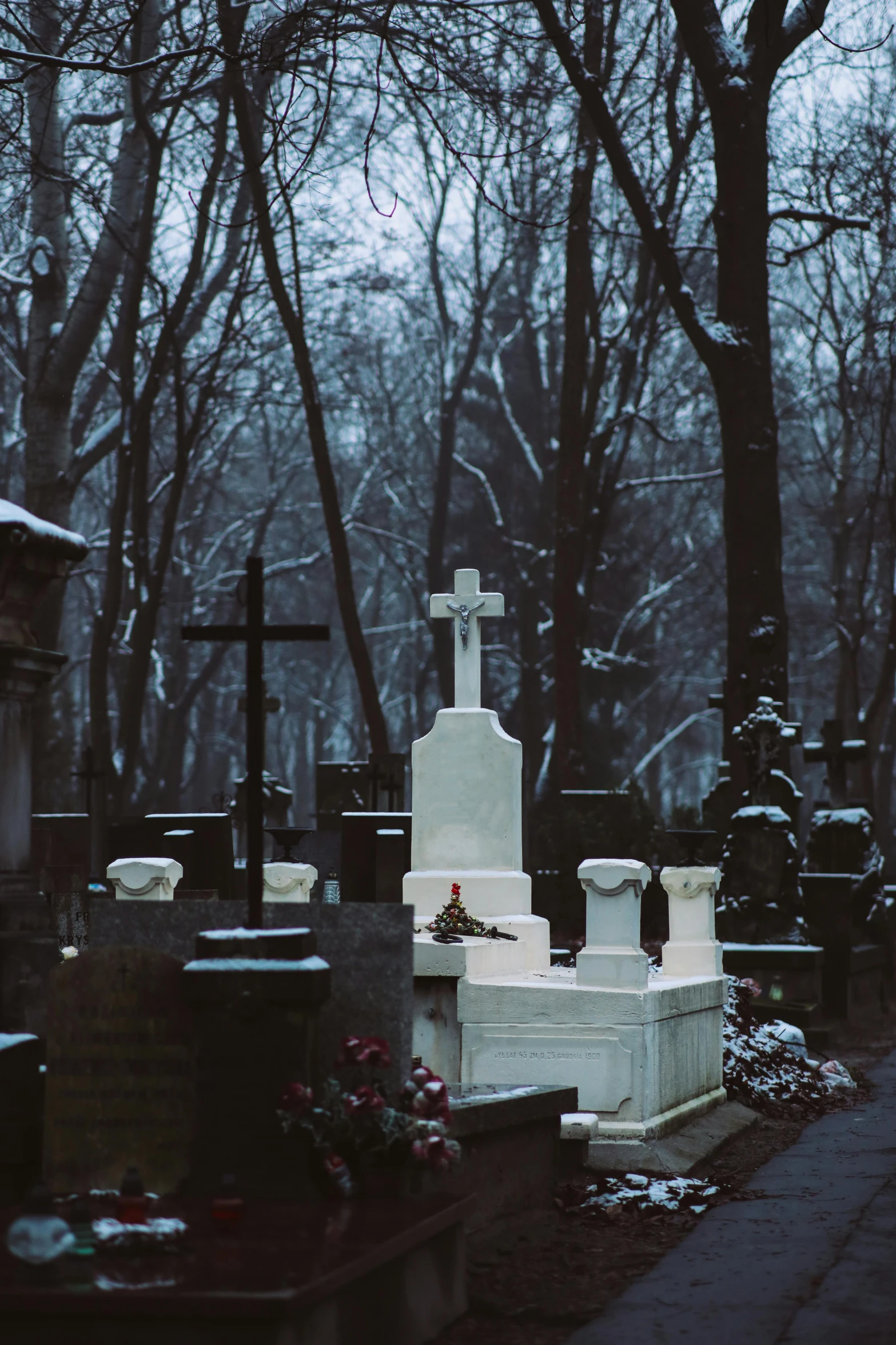 the cemetery in the snow has flowers and crosses