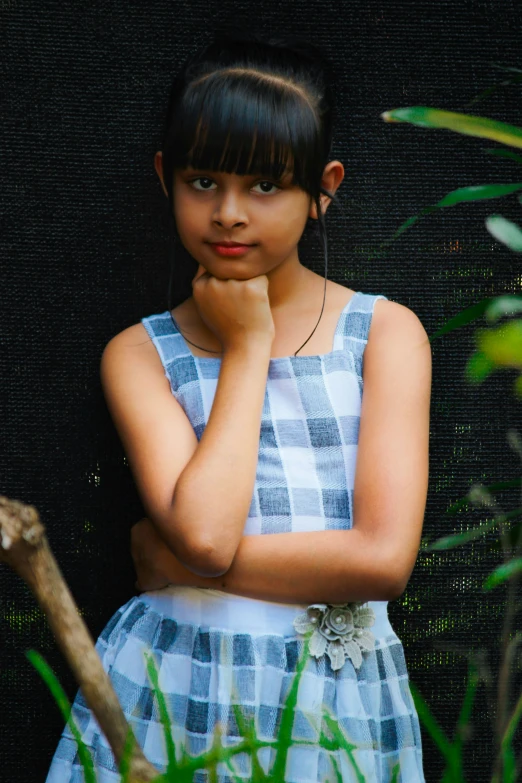 a girl posing for the camera with her chin on her chest