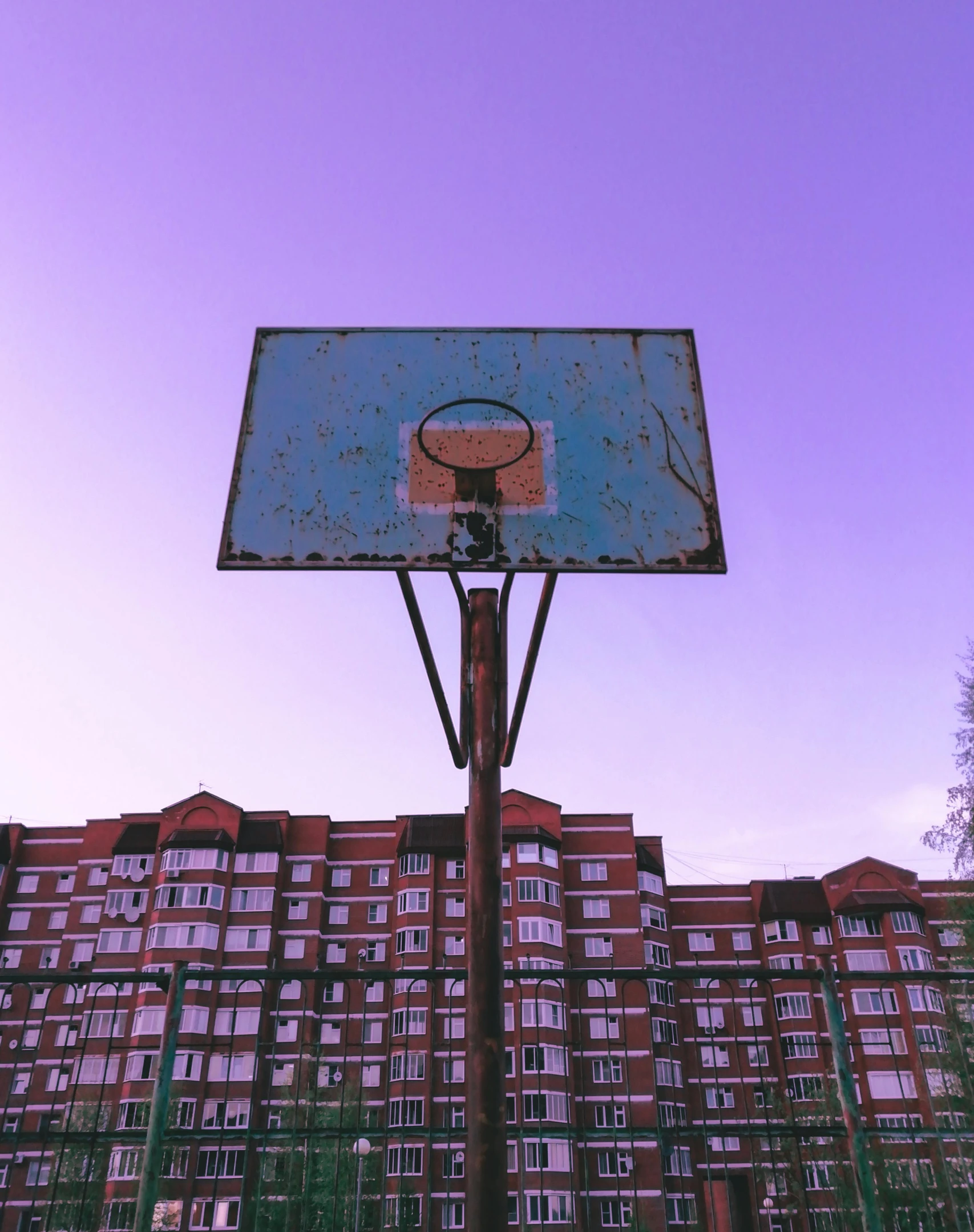 an old basketball court and a building are in the background