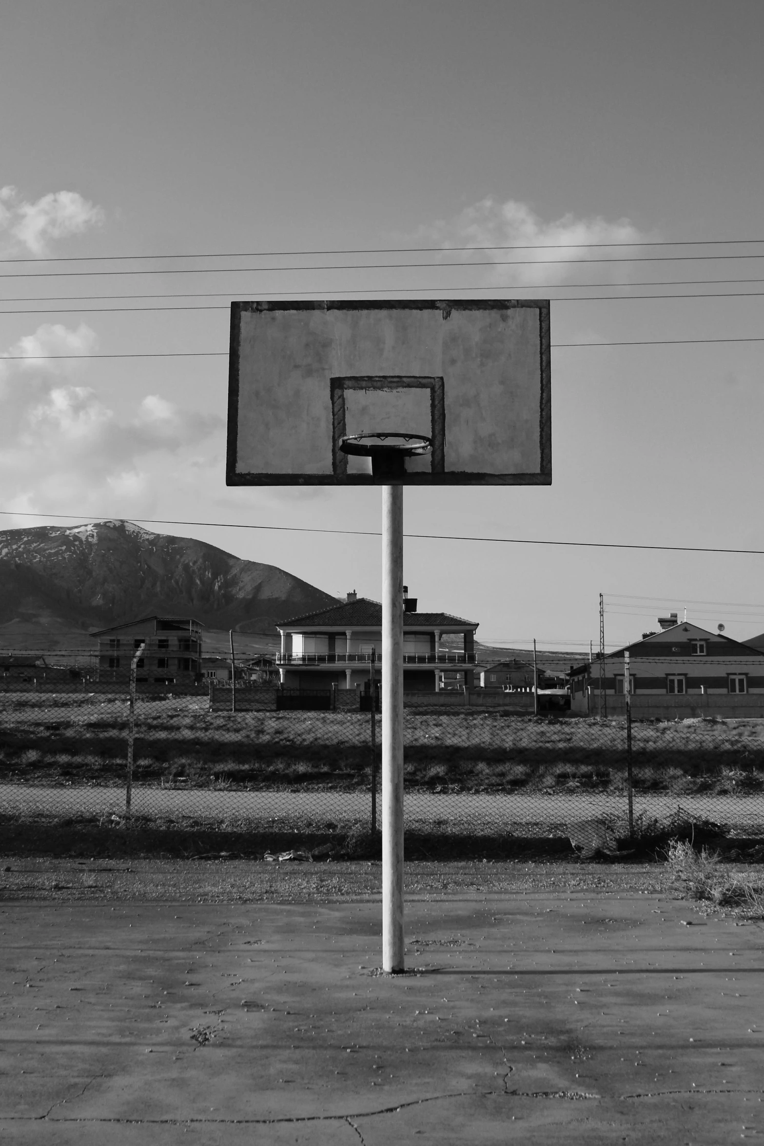 a basketball court with a basket and a view of some mountains