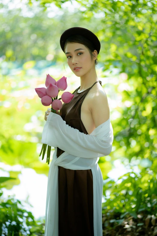 a woman is holding three pink flowers