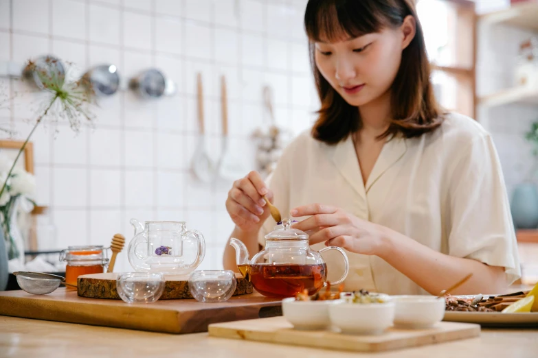 a woman pours tea in a glass cup