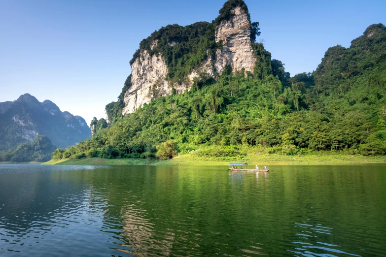 there is a boat on the lake near mountains