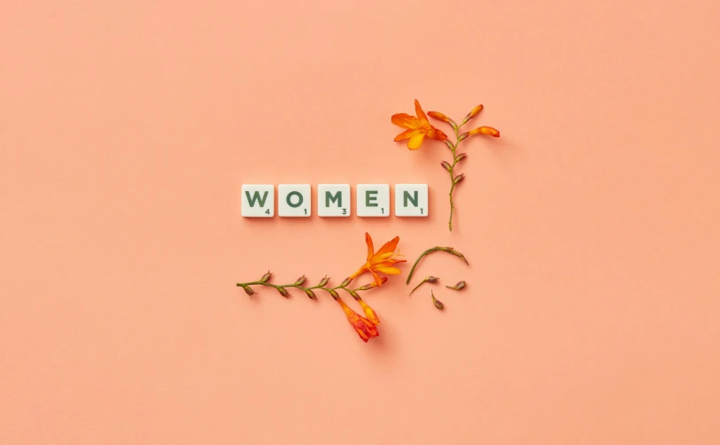 a flower is placed near the letters that read women