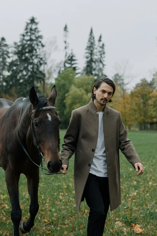 a man walking his horse with both hands