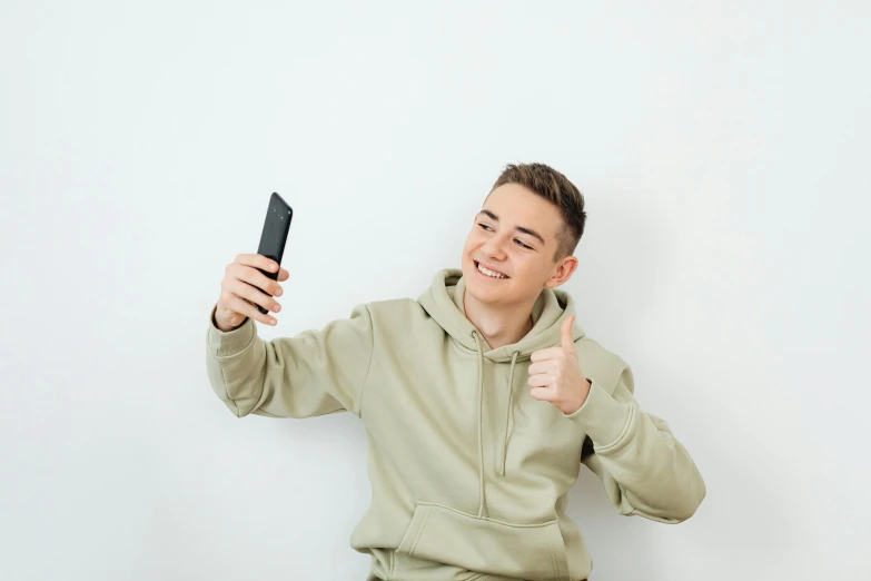 man holding up an item while giving a thumbs up