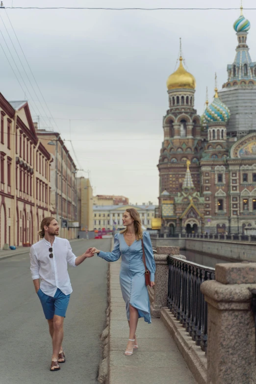 two people walking along the side walk of an alley