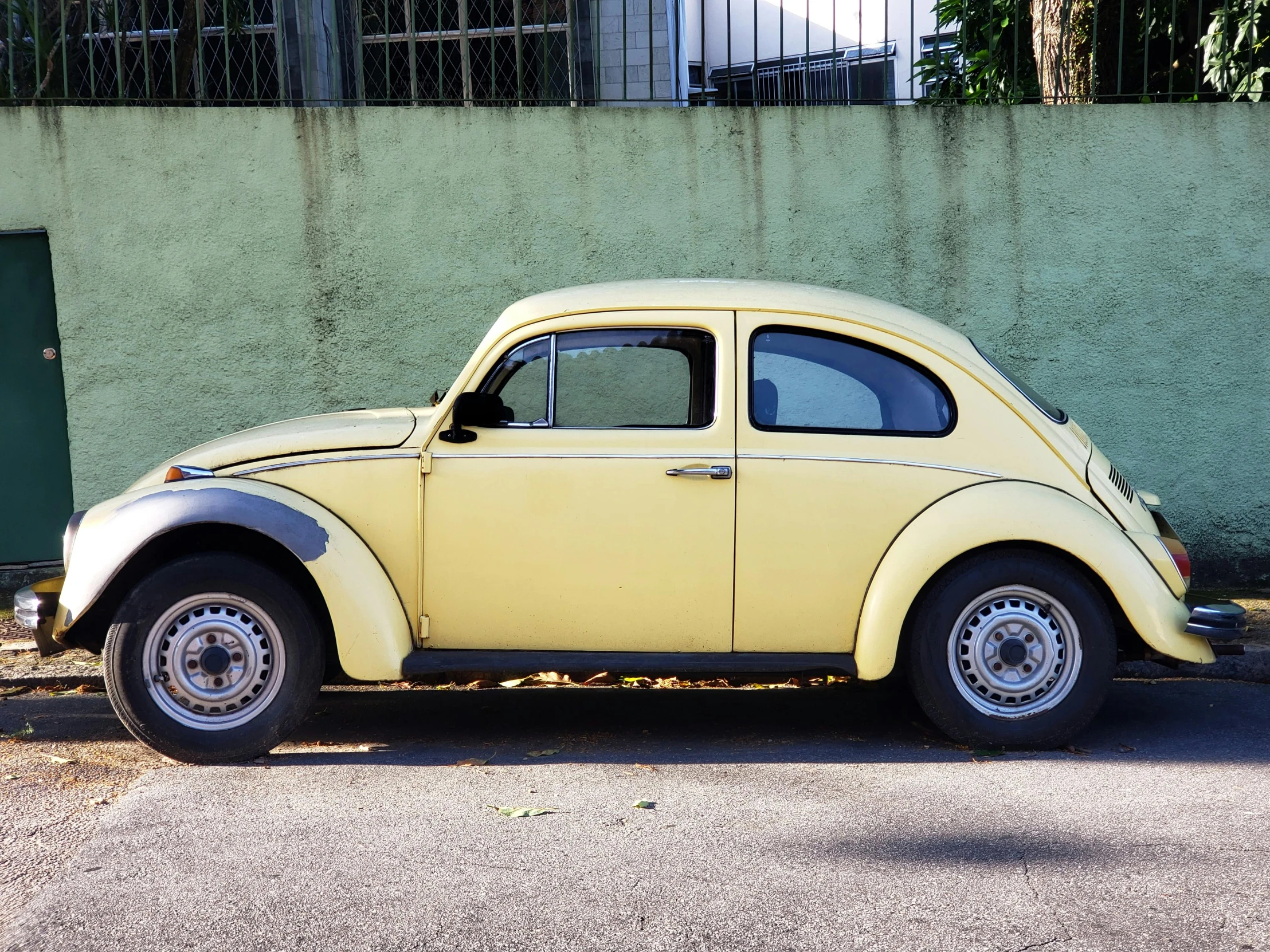 an old fashioned yellow vw beetle parked outside