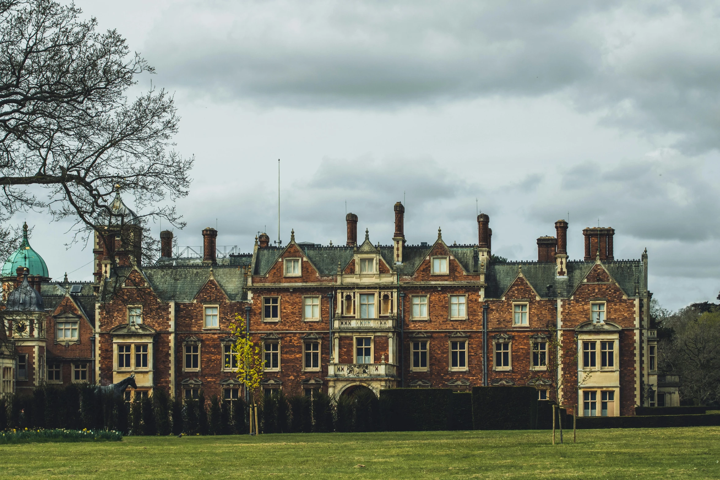 a large brick house sitting next to a tall green tree