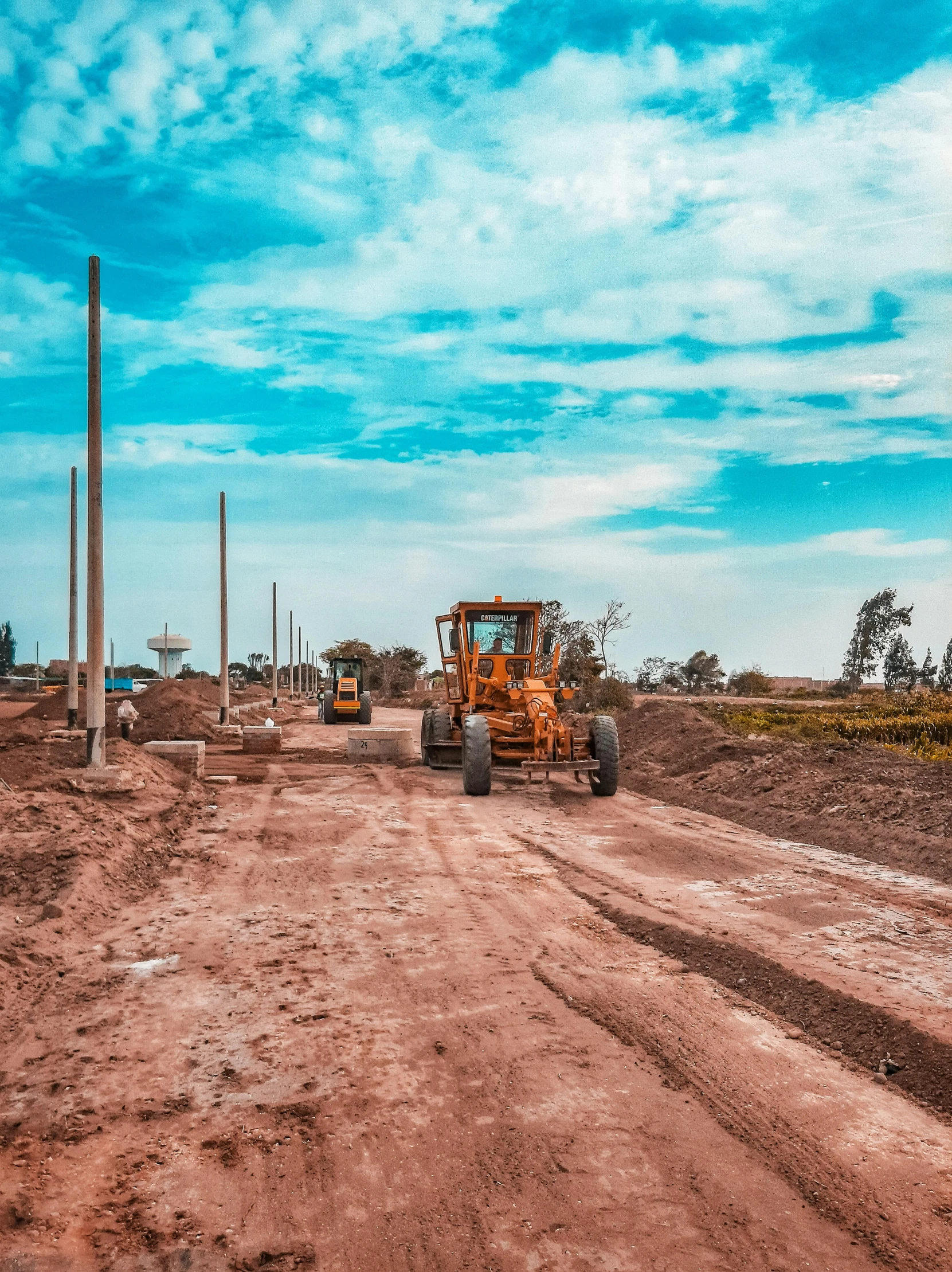 some tractors are driving around in the dirt