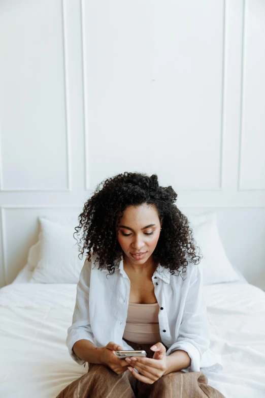 woman sitting on bed reading an app