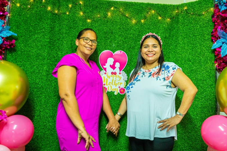 two women standing next to each other with balloon decorations