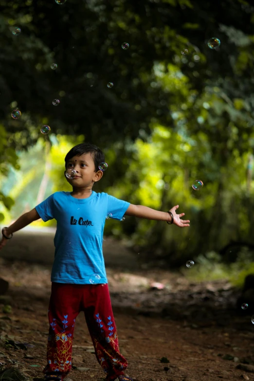 the young child is playing with bubbles on a path