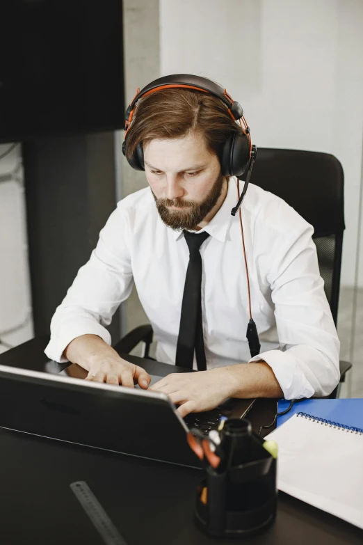 the man in headphones is using a laptop