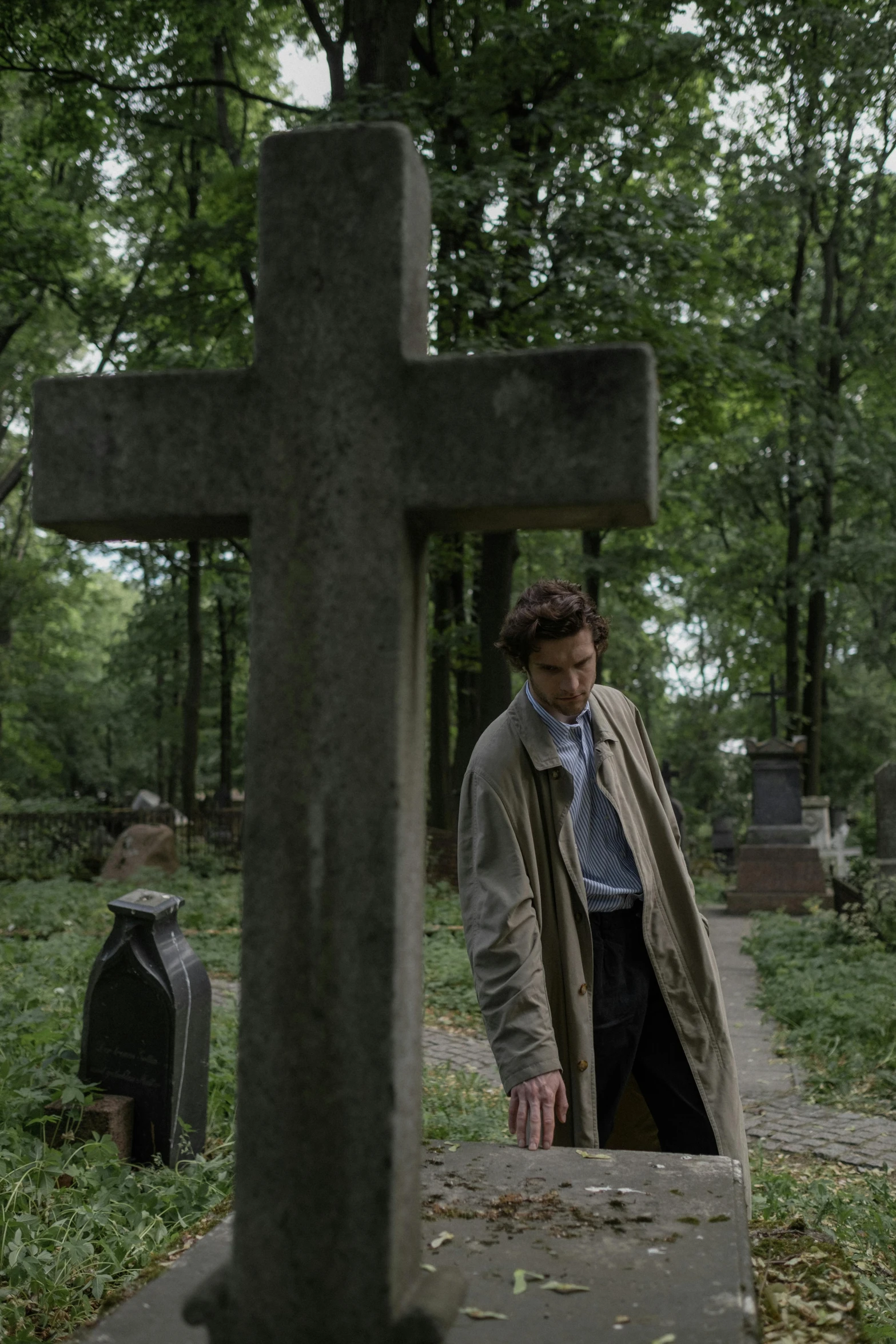 a man with a jacket and tie in a cemetery
