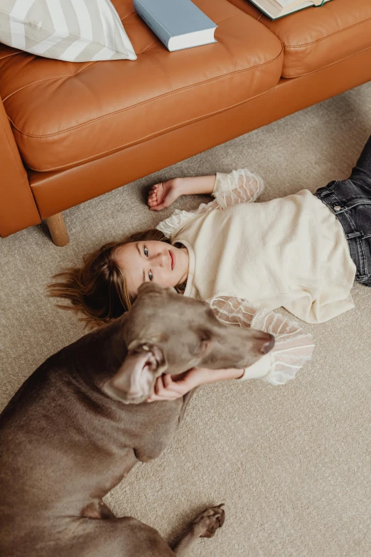 a little girl laying next to a big dog