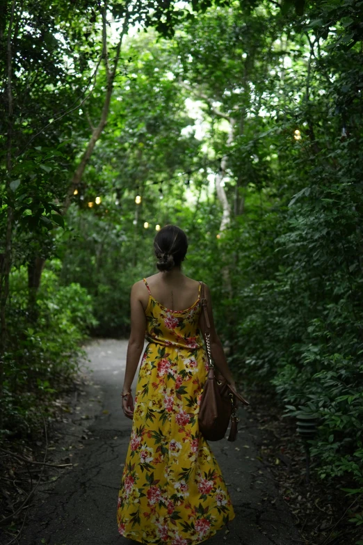 a woman with a handbag walking down a path