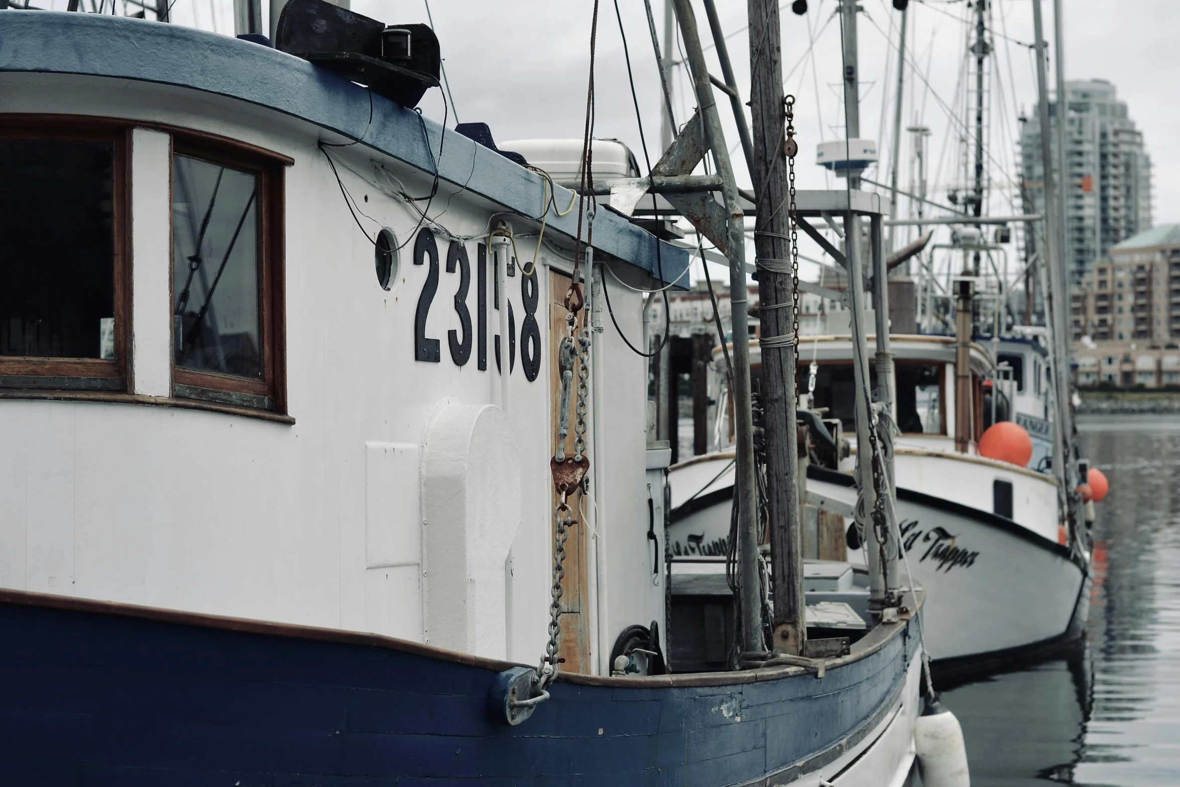 two sailboats tied to the docks in front of some buildings