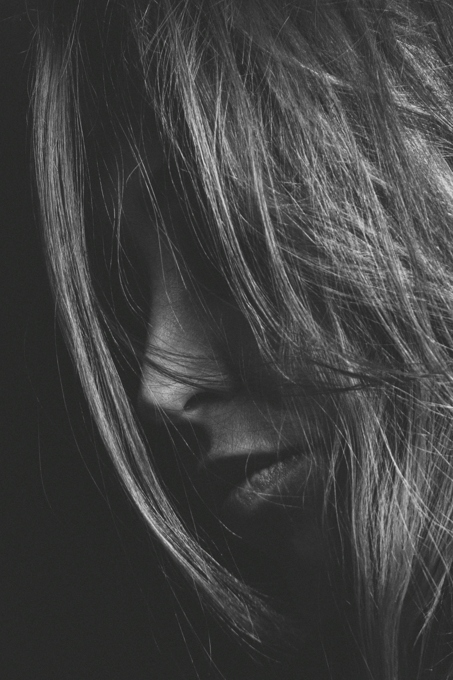 a womans long hair and eyes with one of the light reflecting on her face